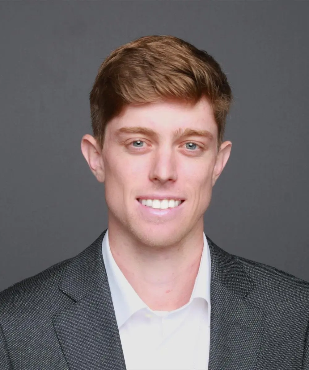 A man in a suit and tie smiling for the camera.